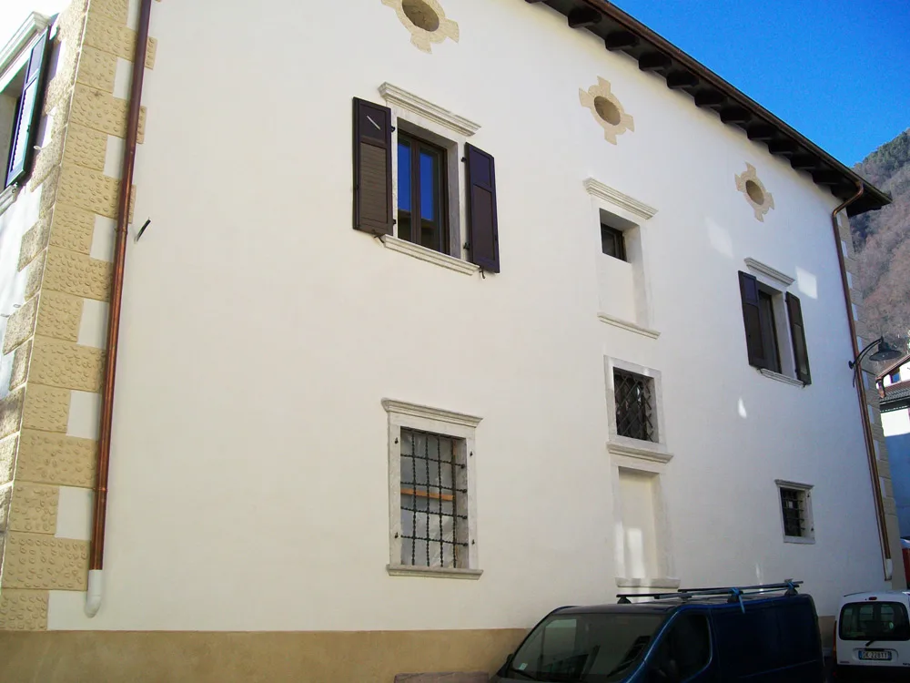 Palazzo Barbi a Cembra, facciata bianca con cantonali in pietra e finestre con inferriate
